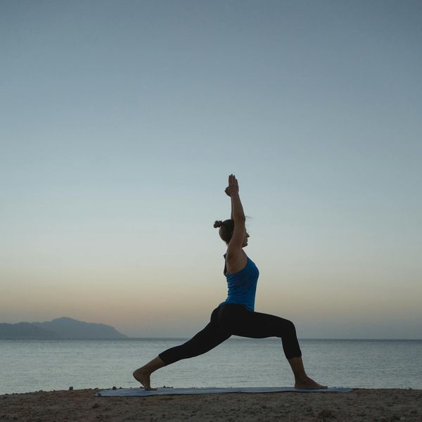 Silhouette of a woman stretching during sunrise, symbolizing renewed energy.